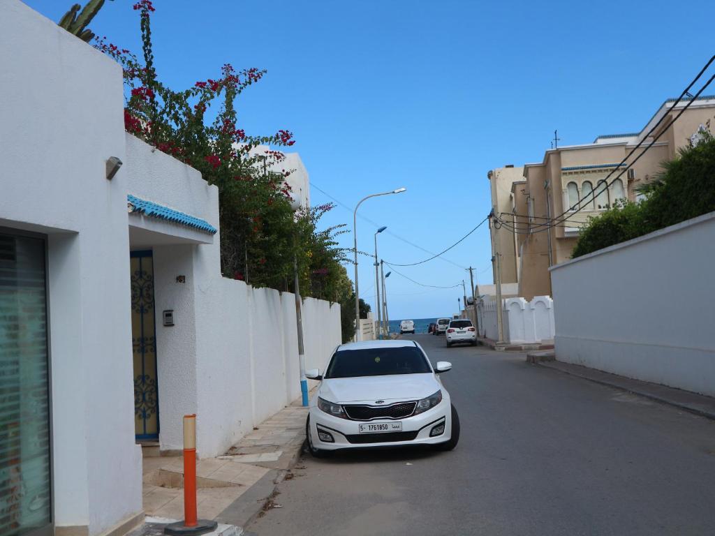a white car parked on the side of a street at Appartment Central Hammam Sousse plage in Sousse
