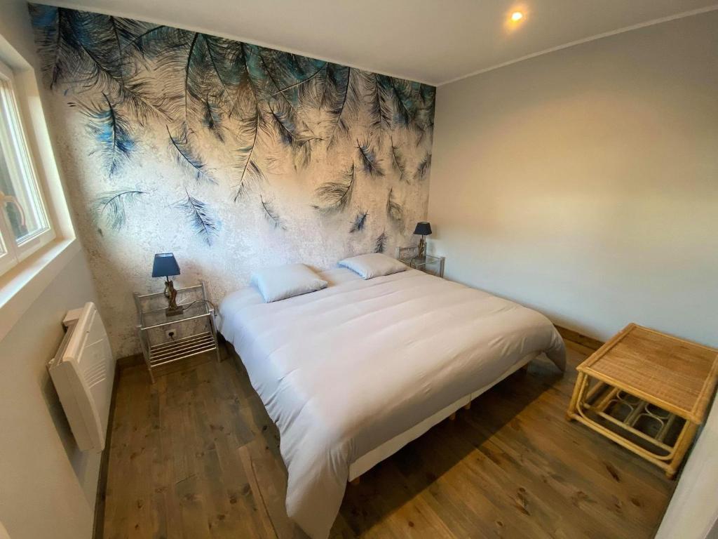 ein Schlafzimmer mit einem großen Bett und einem Gemälde an der Wand in der Unterkunft Studio 41 in Eppeville