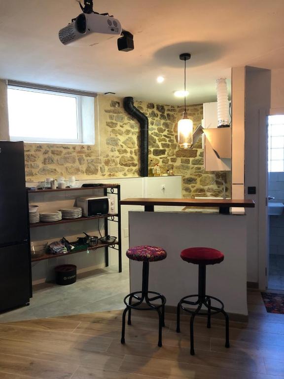 a kitchen with two bar stools and a counter at El nido del Rusiñol in Cervera de Pisuerga