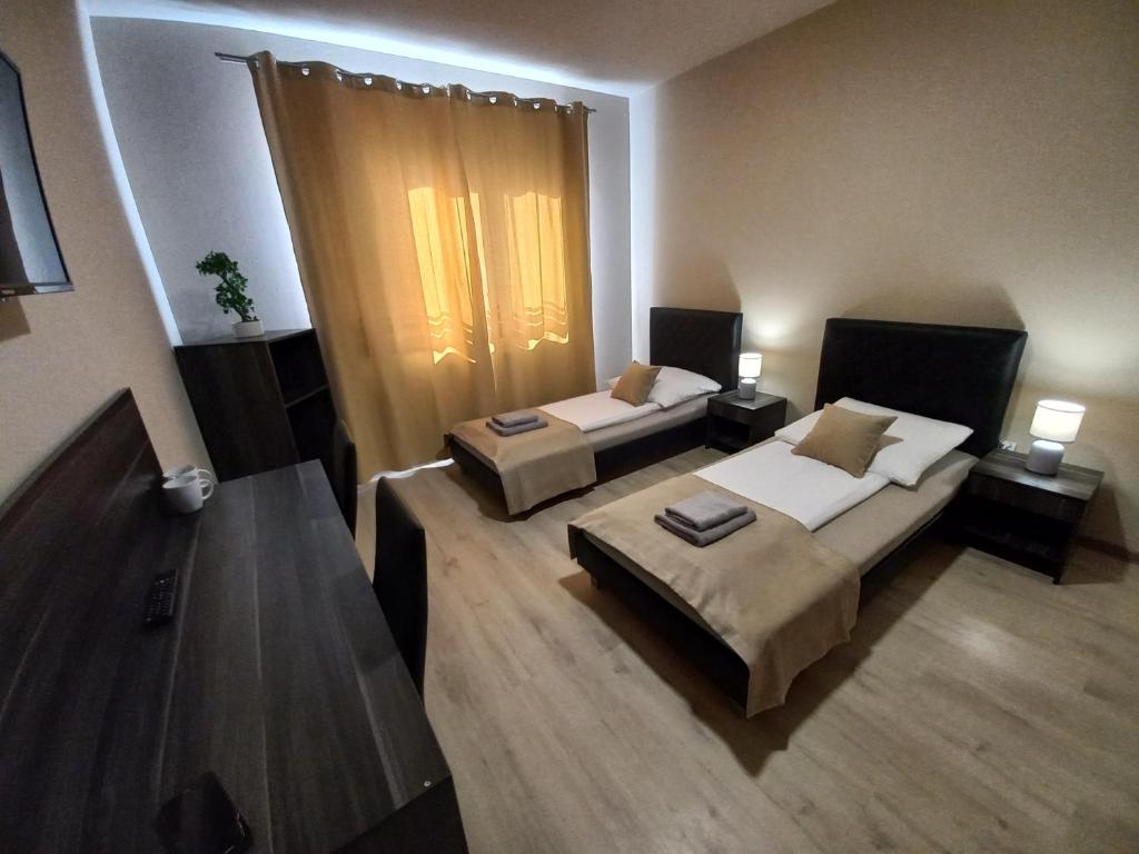 a room with two beds and two tables in it w obiekcie Good Night noclegi - wjazd do Bielsko Biała od Katowic droga E75 , S1 w mieście Czechowice-Dziedzice