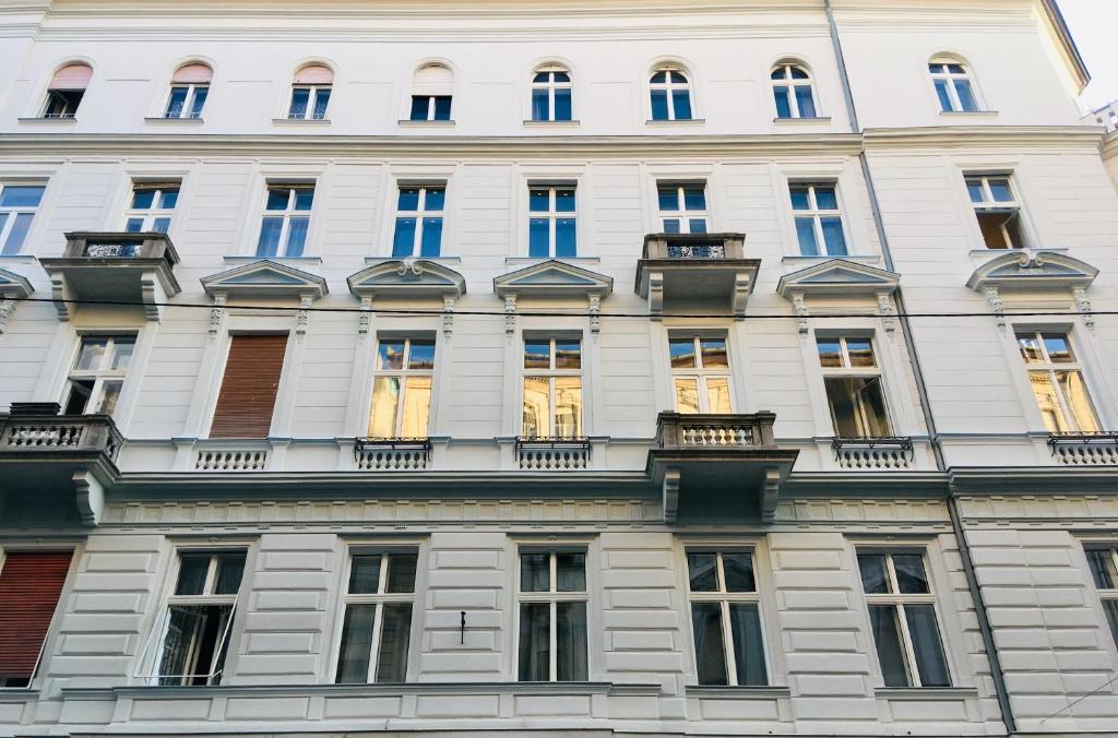 un gran edificio blanco con muchas ventanas en Eclectic Luxury & Spacious 2BR AC Apt in Center, en Budapest