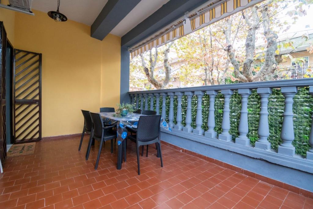 a balcony with a table and chairs and a large window at Casa ilaria in Ladispoli