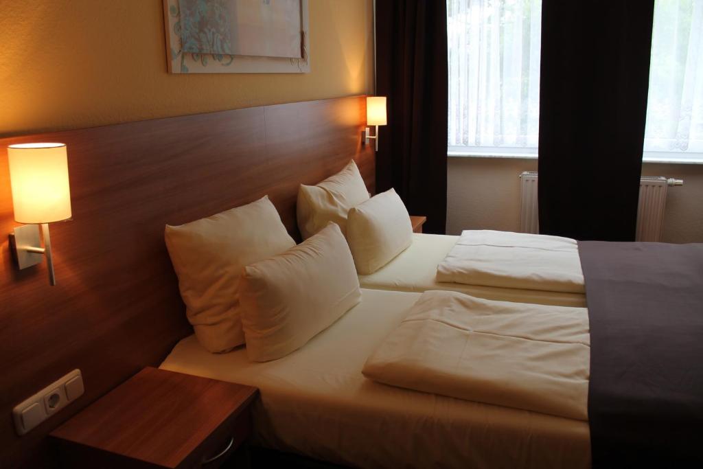 Postel nebo postele na pokoji v ubytování Hotel Harburger Hof