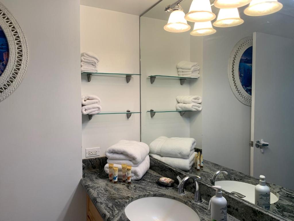 a bathroom with a sink and a mirror at Waikiki Banyan 1812 Spacious Tropical Oasis in Honolulu