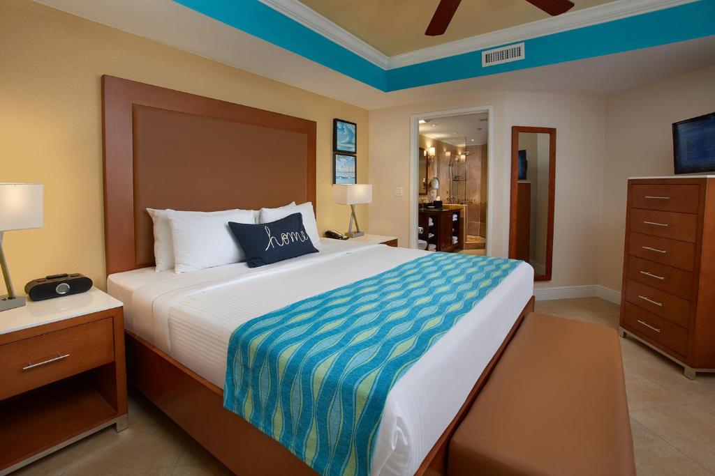 een slaapkamer met een groot bed en een dressoir bij Divi Ocean View Suite, Aruba in Palm-Eagle Beach