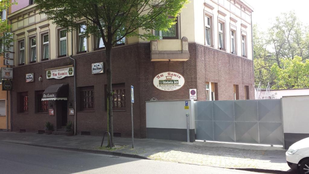 un bâtiment en briques avec une clôture devant lui dans l'établissement Hotel Am Kamin, à Duisbourg