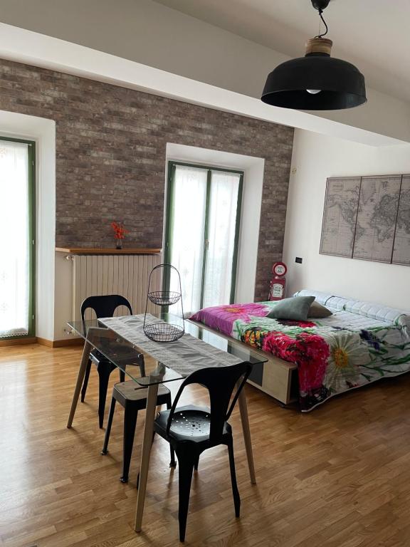 1 dormitorio con 1 cama, mesa y sillas en Una finestra sul centro storico, en Reggio Emilia