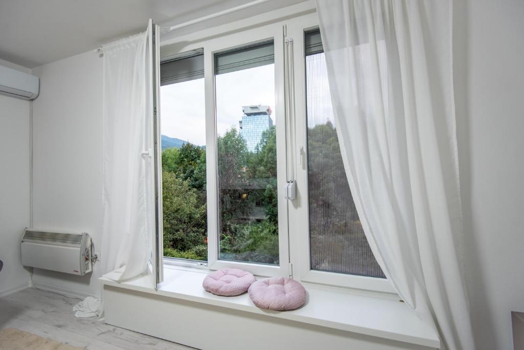 a window with pink pillows on a window sill at Apartment Kalemova in Sarajevo