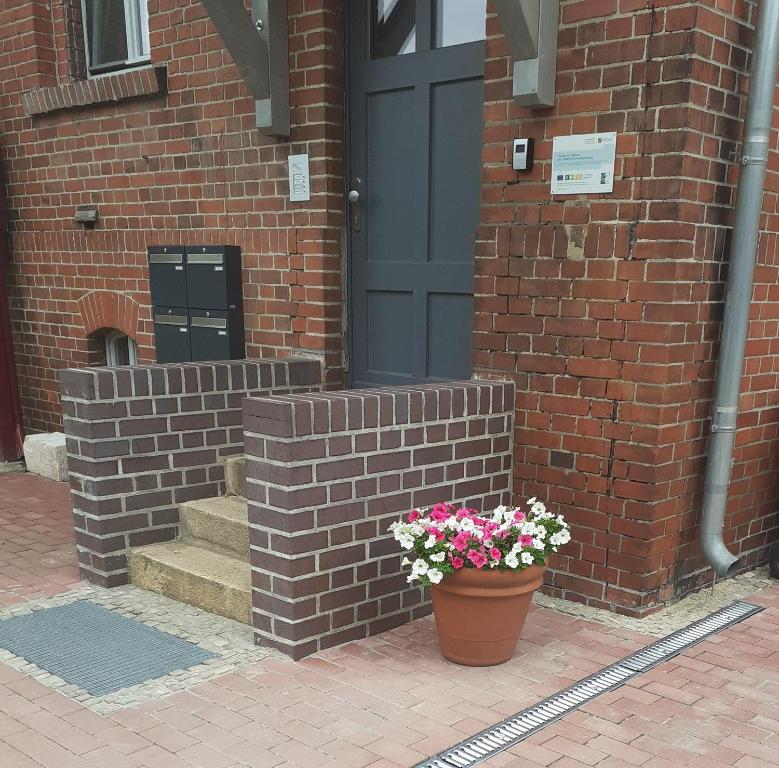 a brick building with a door and a pot of flowers at Rietschen, Natur erleben in Rietschen