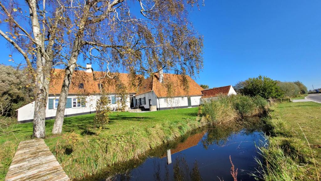 una casa con un canal frente a ella en Hoeve Spyckergoed, en De Haan