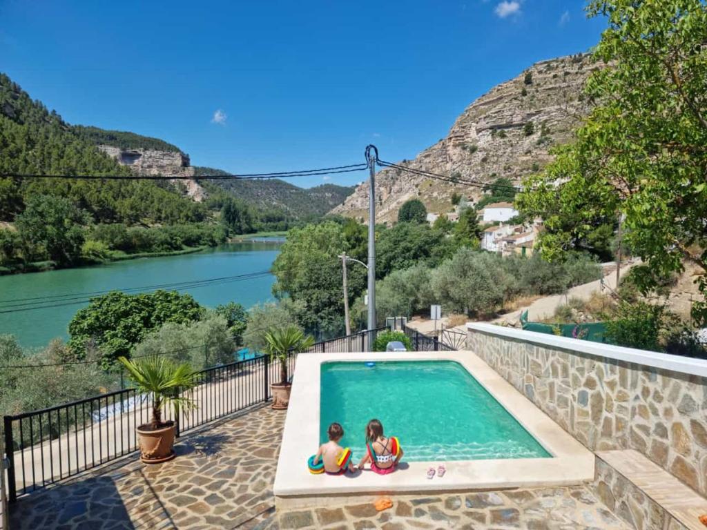 dos niños sentados en una piscina junto a un río en ALCALA DEL JUCAR, Casa rural Rio Tranquilo 1 -Piscina privada-, en Tolosa