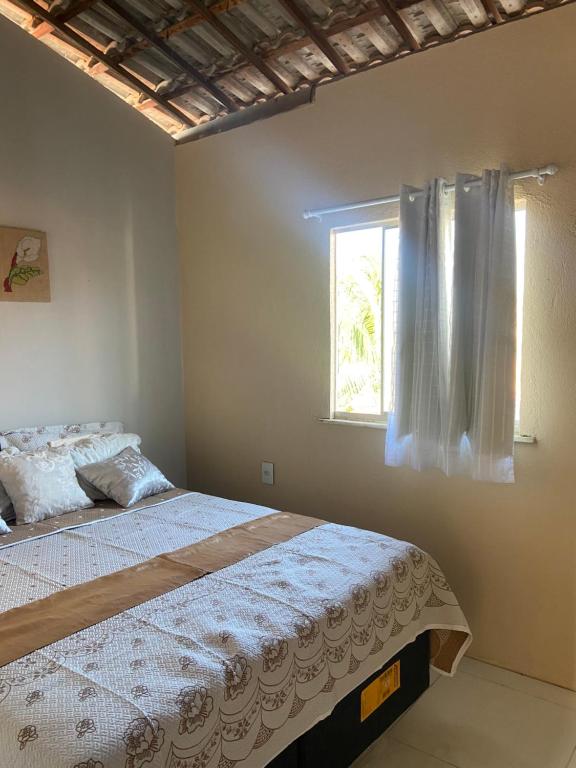 a bedroom with a bed and a window at Pousada Vila do Mar in Taíba