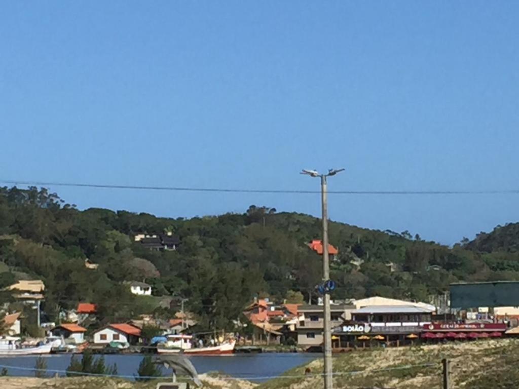 a town on a hill with a body of water at APARTAMENTO 3 DORM., O QUINTAL É A PRAIA E MOLHES in Laguna
