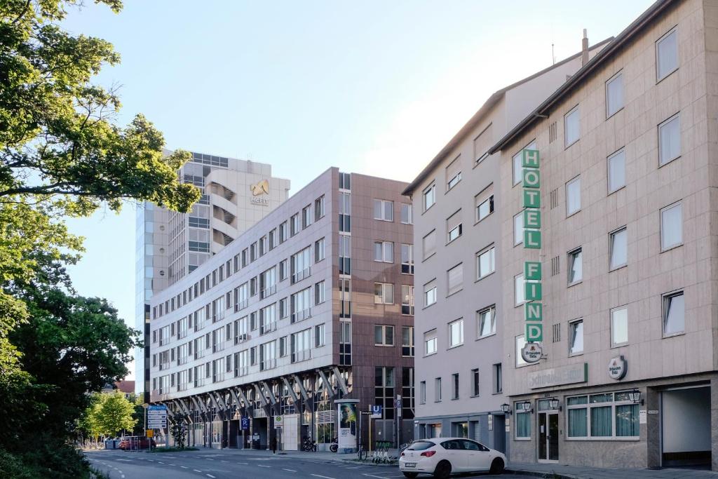 a building on a street with a white car parked in front at Hotel Find in Stuttgart