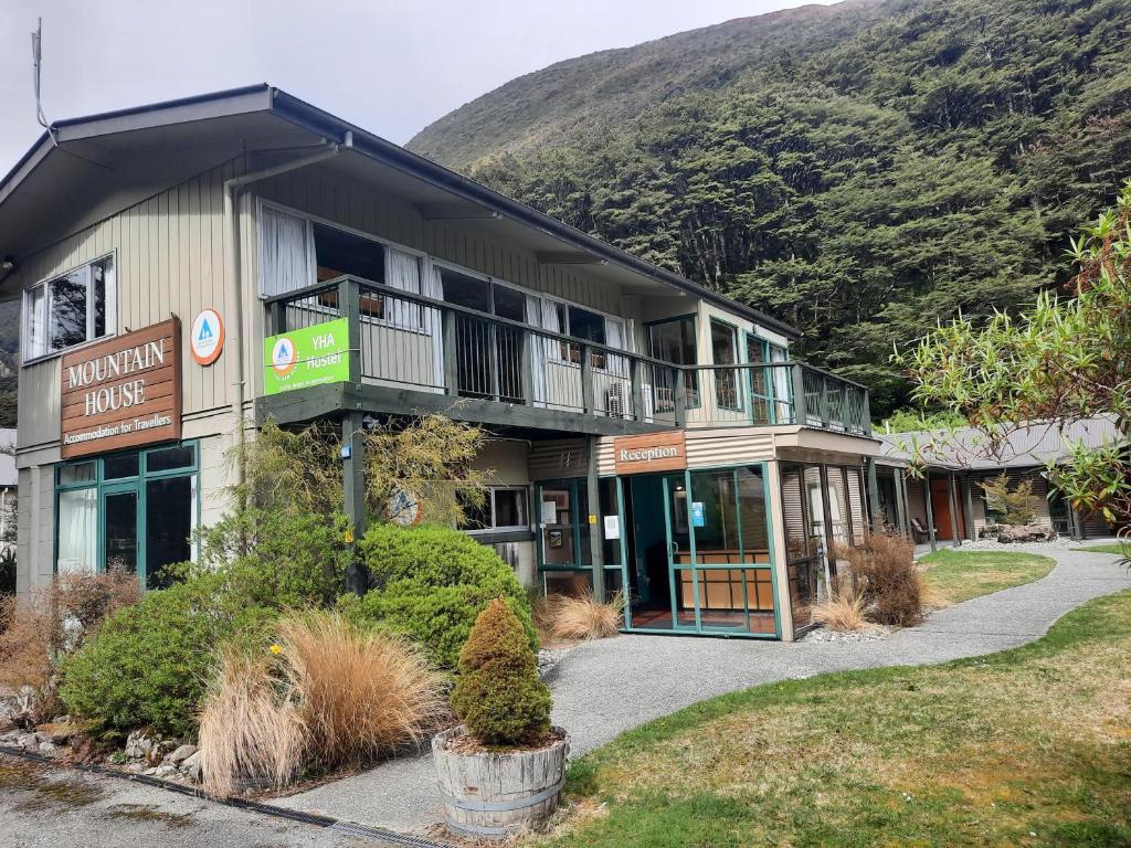 a large building with a mountain in the background at Mountain House in Arthur's Pass