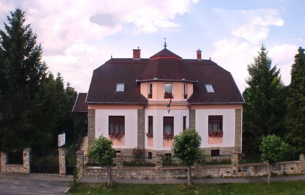 une maison blanche avec un toit marron dans l'établissement Illés Vendégház, à Keszthely