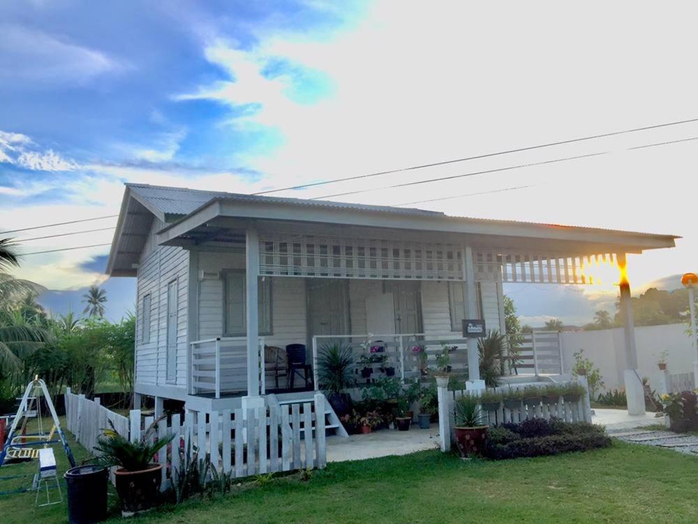 una piccola casa con una recinzione di fronte di Tok Abah Cottage a Kota Bharu
