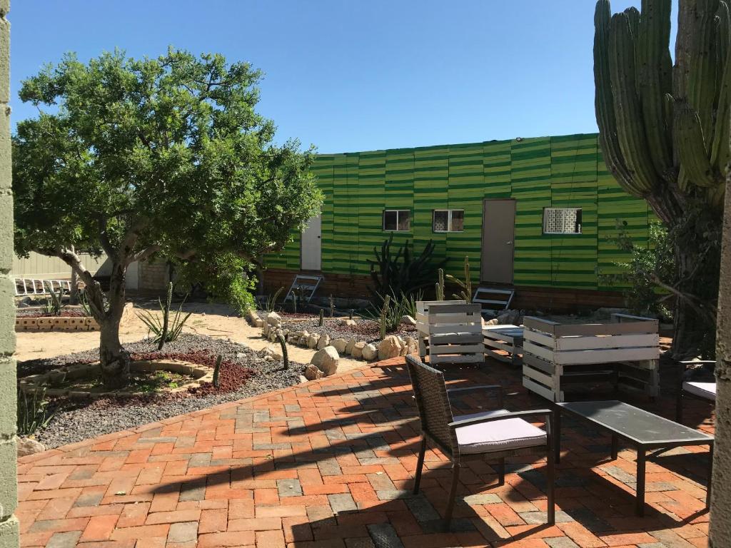 un patio con mesa y sillas y un edificio verde en Susu’Z Village Hostel and Rooms, en La Ventana
