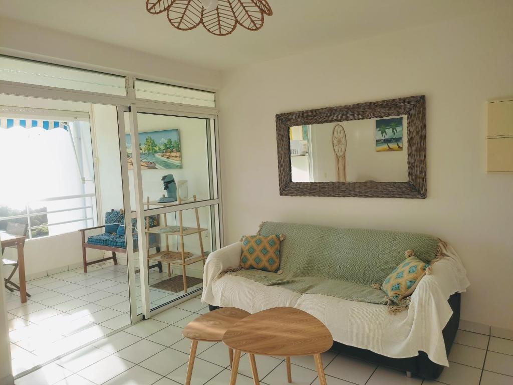 a living room with a couch and two stools at Appartement T2 Sainte Anne Caritan Melody Sunset in Caritan