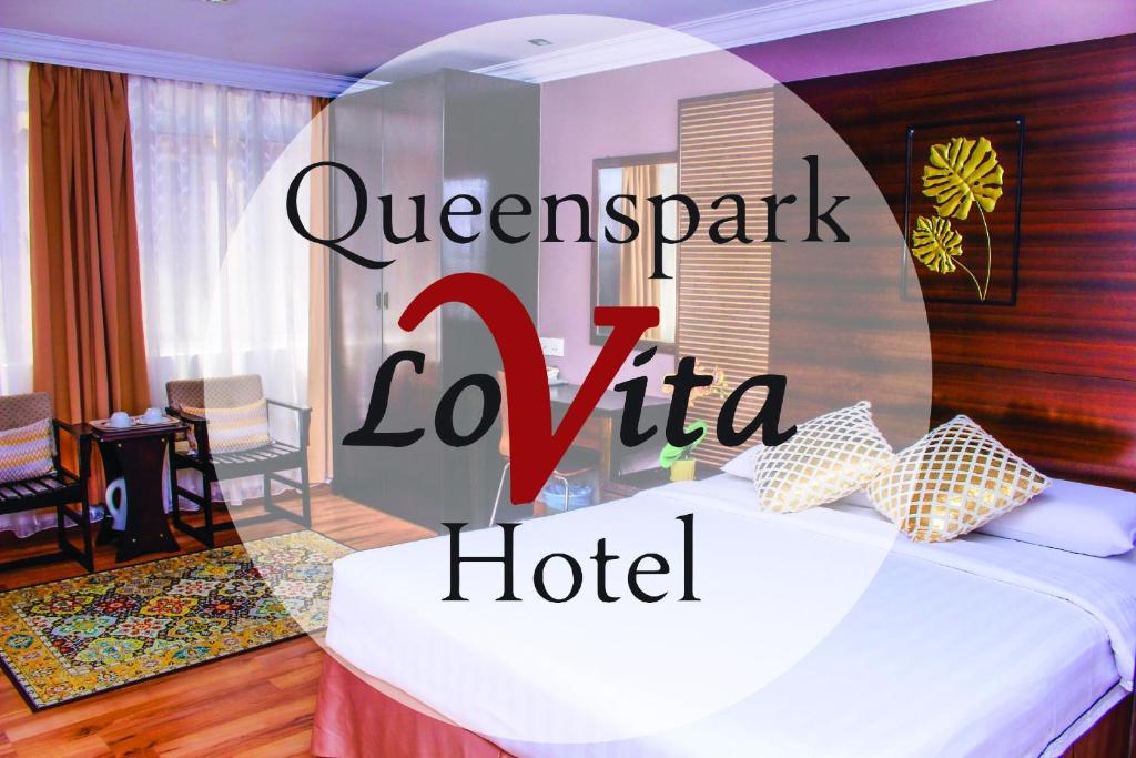 a hotel room with a bed and a hotel sign at Queenspark Lovita Hotel in Melaka