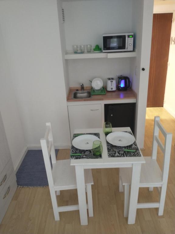 Il comprend une petite cuisine avec une table et des chaises blanches. dans l'établissement Verde Esmeralda, à Buenos Aires