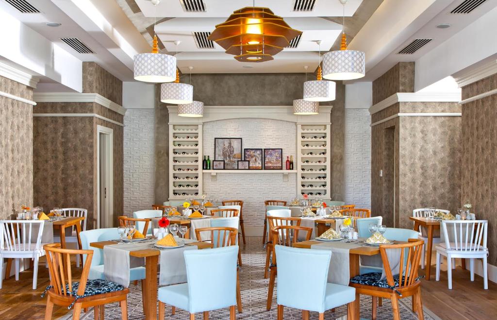 a rendering of a dining room with tables and chairs at Grand Park Lara Hotel in Lara
