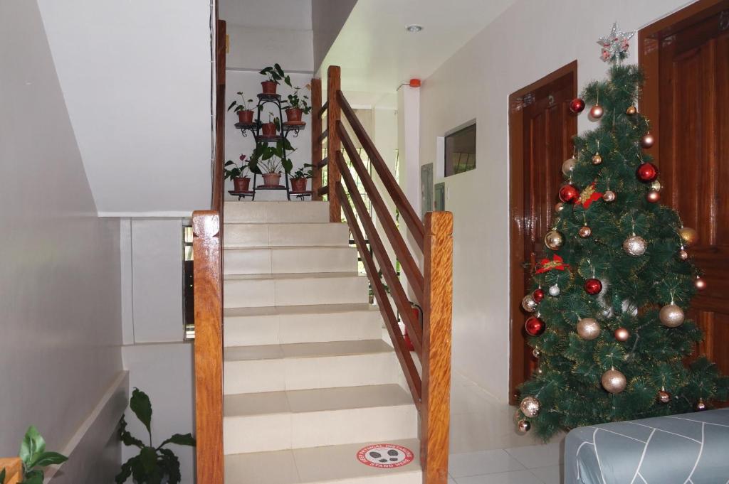 a christmas tree in a living room with a staircase at Sheryl May Inn in El Nido