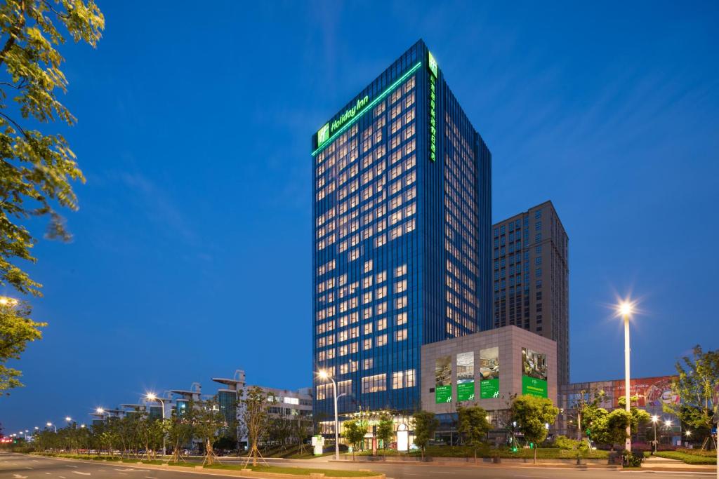 wysoki budynek w mieście w nocy w obiekcie Holiday Inn Nanjing Harbour, an IHG Hotel w mieście Nankin