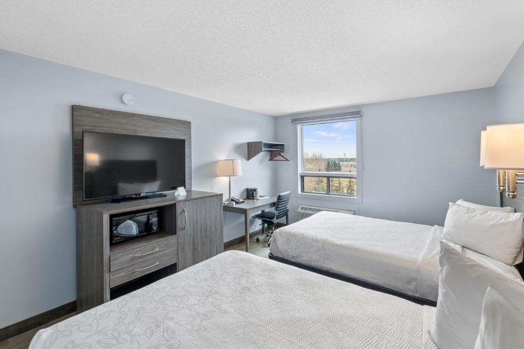 Postel nebo postele na pokoji v ubytování Emerald Hotel & Suites Calgary Airport
