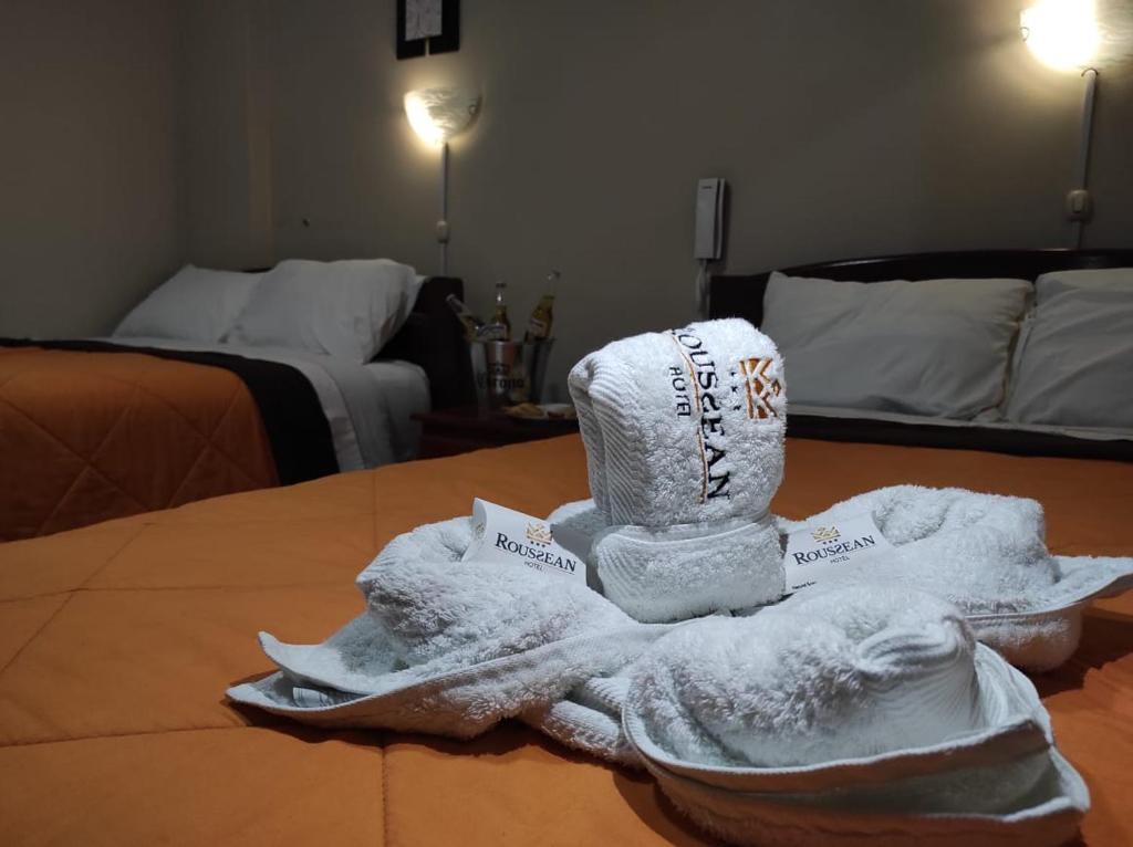 a pile of towels sitting on top of a bed at Hotel Roussean in San Vicente de Cañete