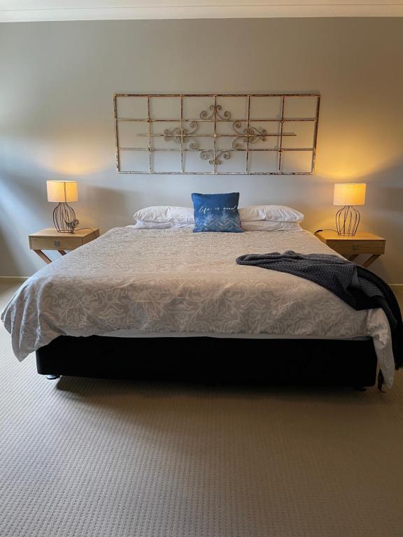 a bedroom with a bed with a blue pillow on it at The Old Coolstore - Braeburn Apt in Merricks North