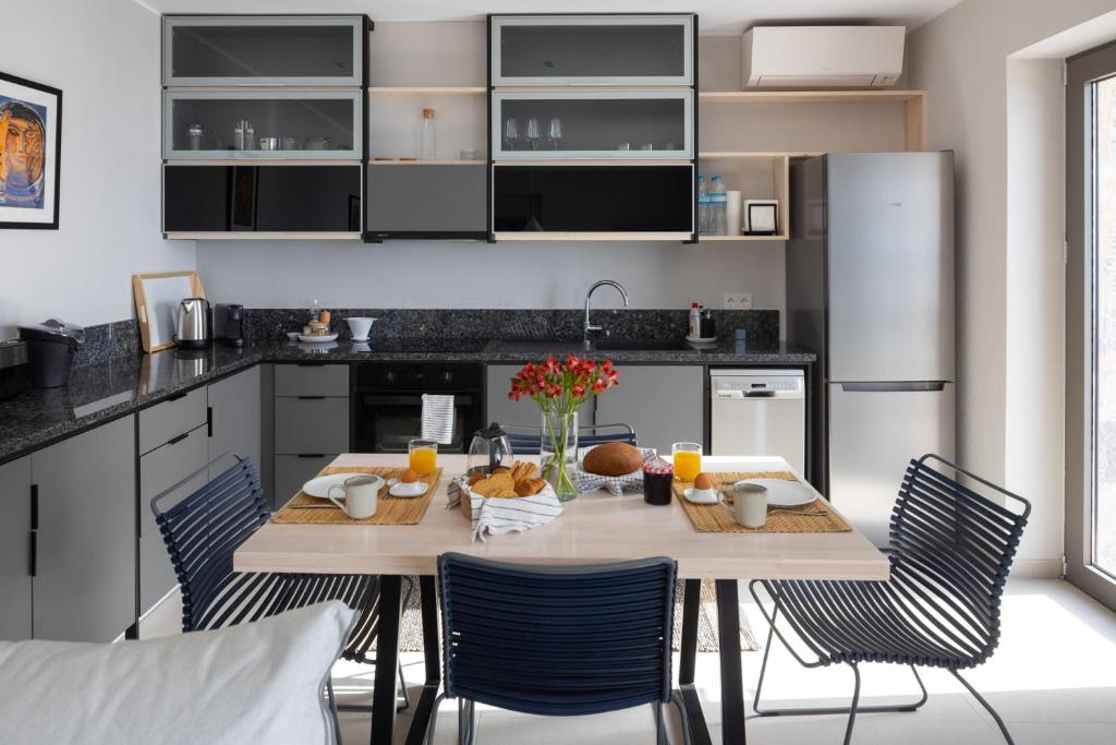 a kitchen with a table and chairs and a kitchen with black cabinets at Kechria Bay Villas in Skiathos