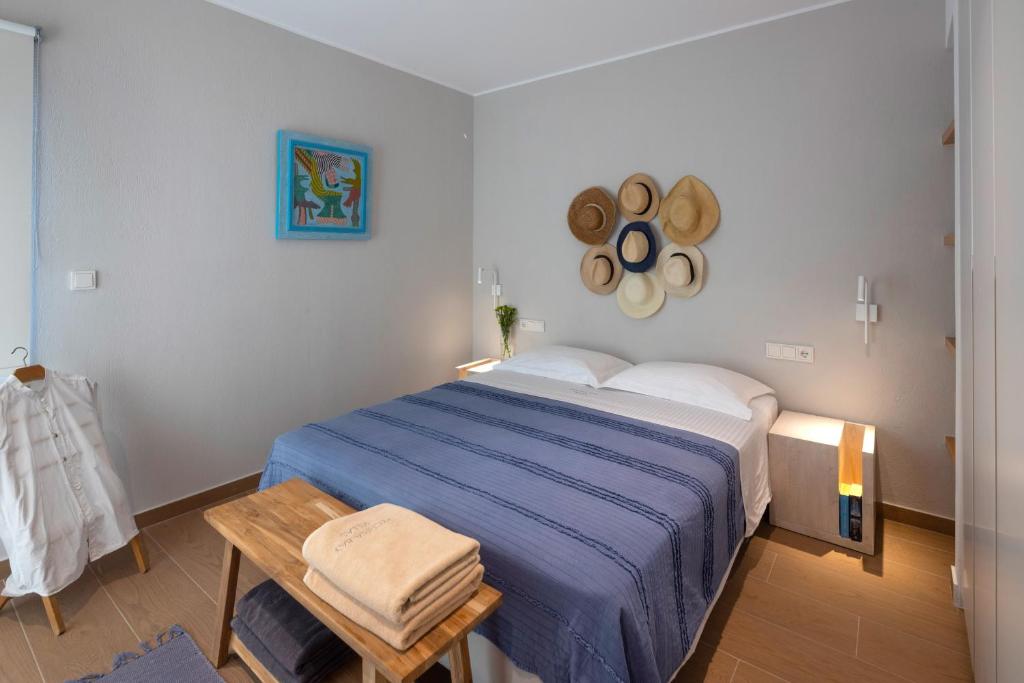 a bedroom with a blue bed and a wooden table at Kechria Bay Villas in Skiathos