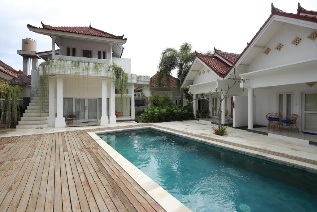 a swimming pool in front of a house at The Sans Kuta Villas in Kuta Lombok