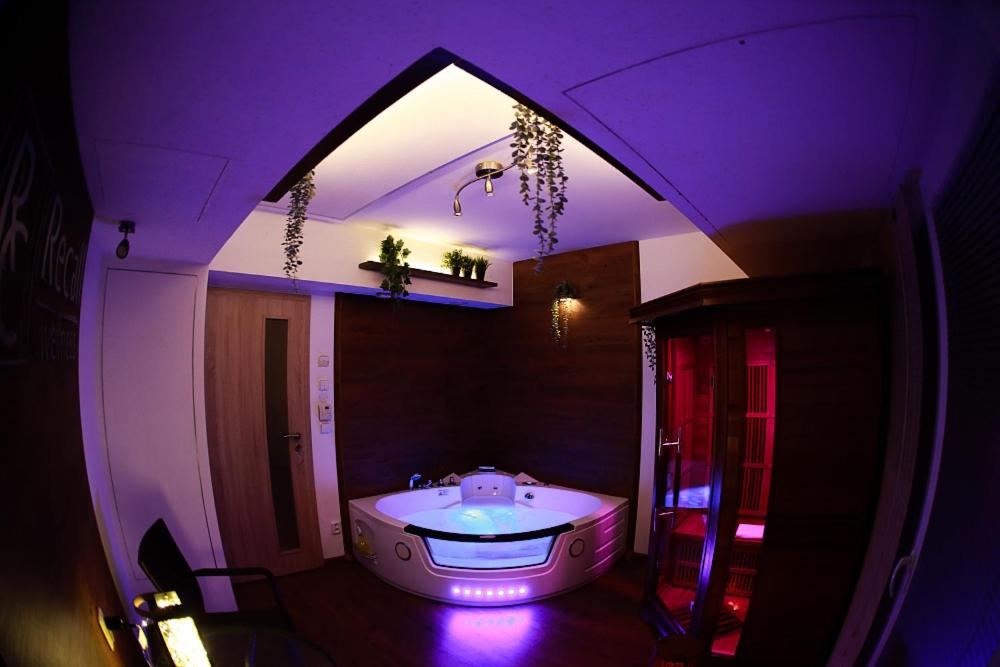 ein Badezimmer mit einer Badewanne in violetter Beleuchtung in der Unterkunft Apartmán Wellness Sedmihorky in Turnov