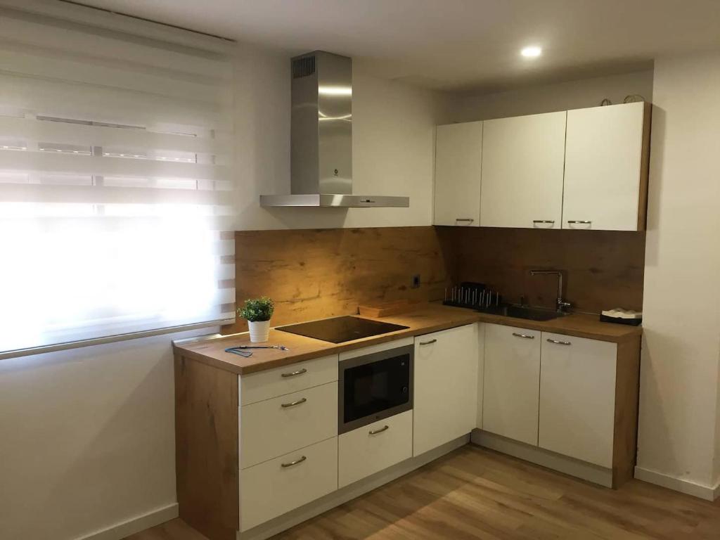 a kitchen with white cabinets and a sink and a window at MAMI / Apto 6 in San Sebastián de la Gomera