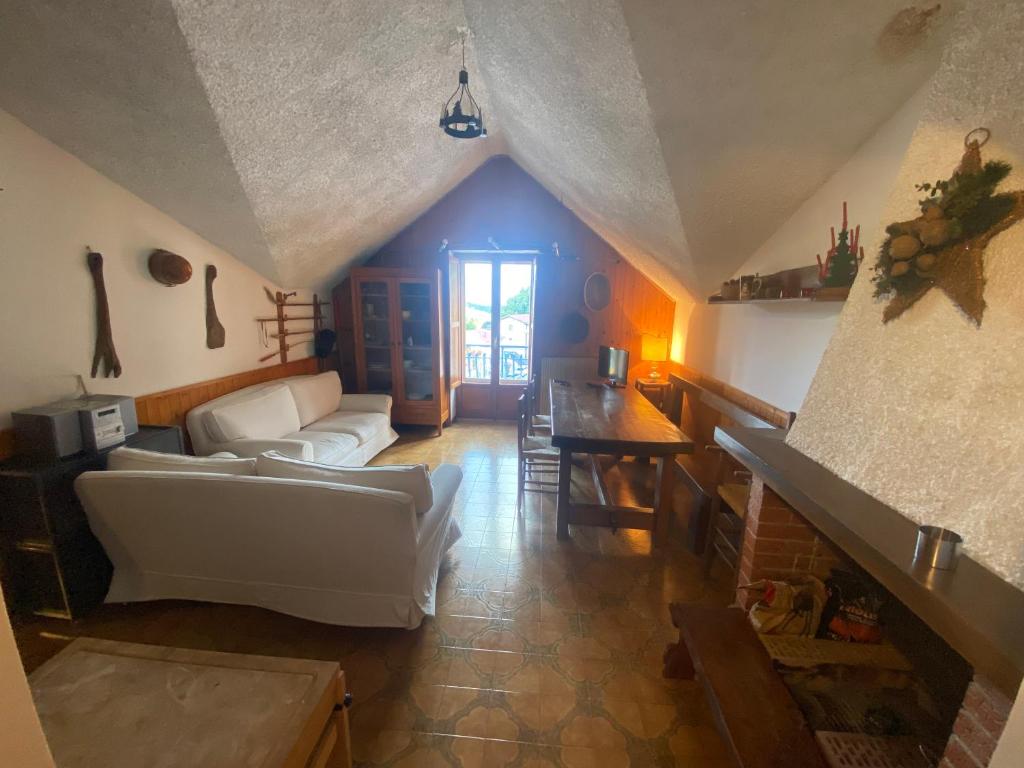 ein Wohnzimmer mit einem Sofa und einem Tisch in der Unterkunft Roccaraso in tasca in Roccaraso