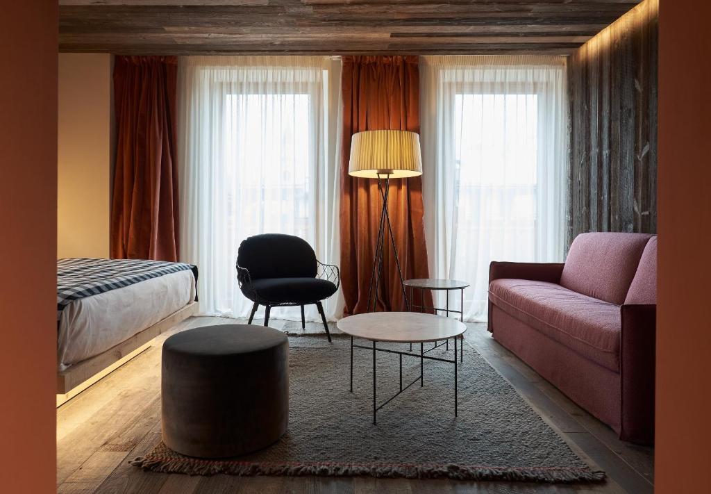 a living room with a couch and a bed at HOTEL de LEN in Cortina dʼAmpezzo