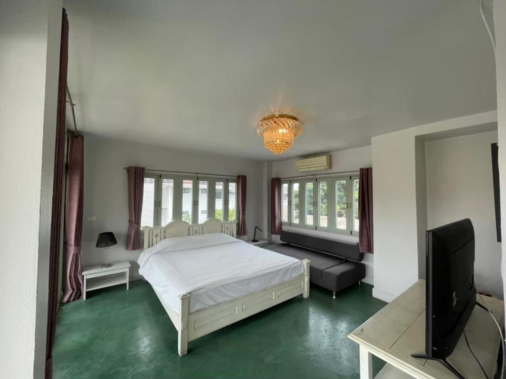 Un dormitorio con una cama y un televisor de pantalla plana. en Villa Duangchampa, en Chiang Mai