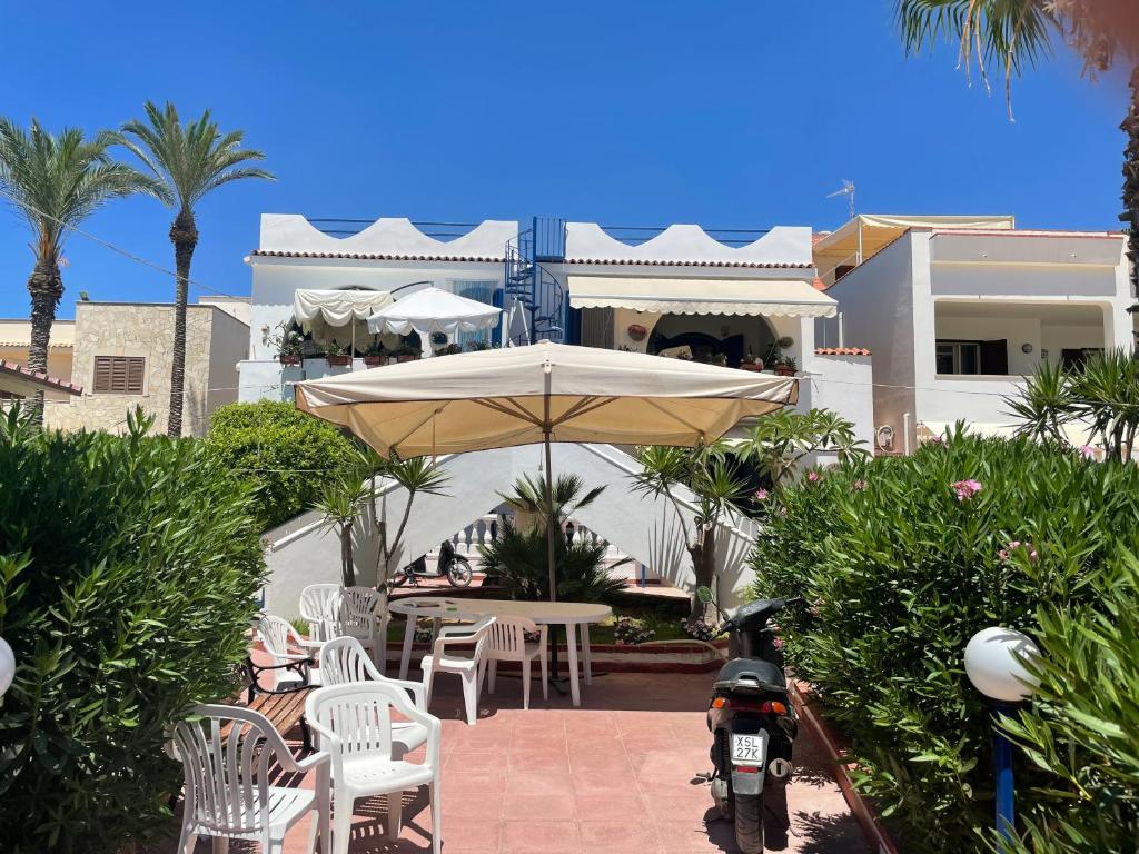 eine Terrasse mit einem Tisch und einem Sonnenschirm vor einem Haus in der Unterkunft Villa del Nonno in Mazara del Vallo