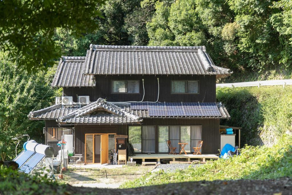 een klein huis met een dak erop bij Kizuna Guesthouse 