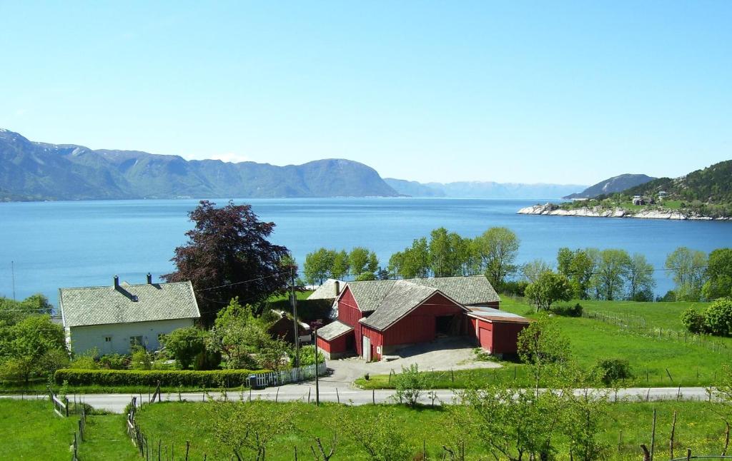 una casa en una colina junto a un cuerpo de agua en Klævold utleigehus en Klevoll