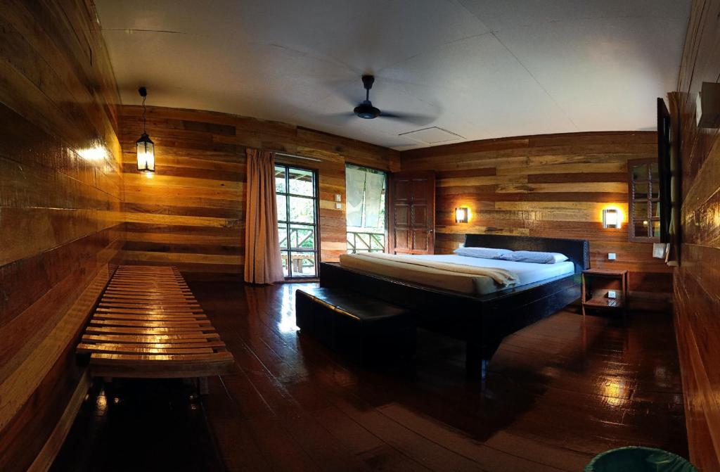 a bedroom with a bed and a bench in it at The Last Frontier Boutique Resort in Bilit