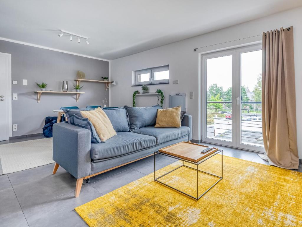 a living room with a blue couch and a table at limehome Montabaur Am Quendelberg in Montabaur