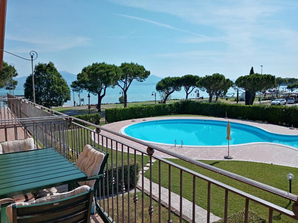 a balcony with a view of a swimming pool at Mosaici Sunrise - lake front apartment with beautiful view in Sirmione