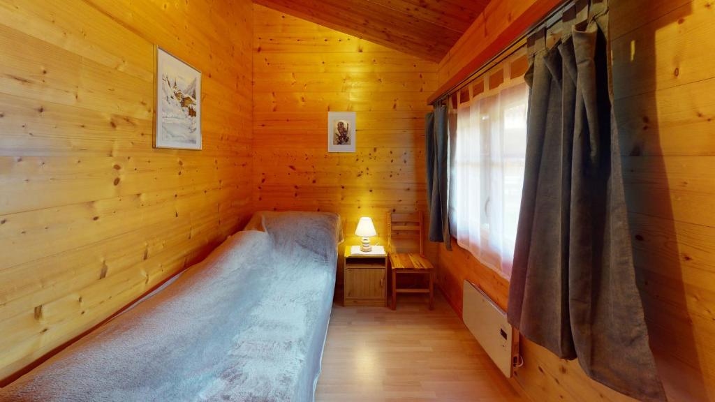 a small room with a bed in a wooden cabin at Chalet Leonie LE0 in Blatten bei Naters