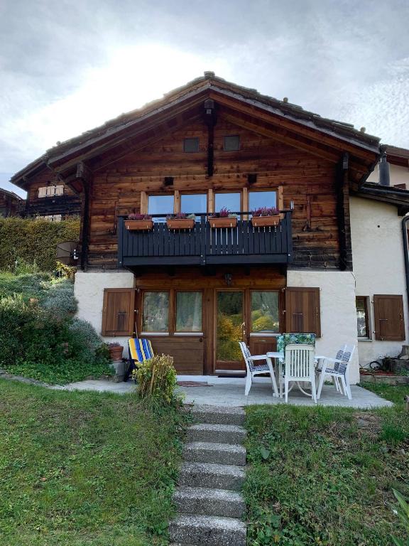 a log cabin with a table and chairs in front of it at Chalet Leonie LE0 in Blatten bei Naters