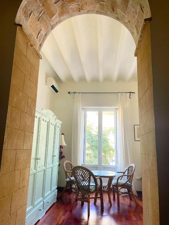 einen Torbogen in einem Esszimmer mit einem Tisch und Stühlen in der Unterkunft Eva Recommends Porvenir Apartment in Jerez de la Frontera