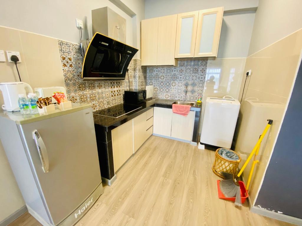 une cuisine avec des armoires blanches et un réfrigérateur dans l'établissement Seaview Apartment, à Kuah