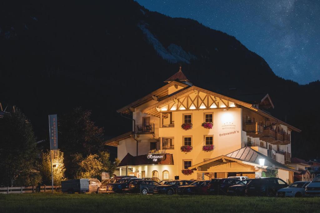 un edificio con coches aparcados delante de él por la noche en Loipenstubn en Brixen im Thale